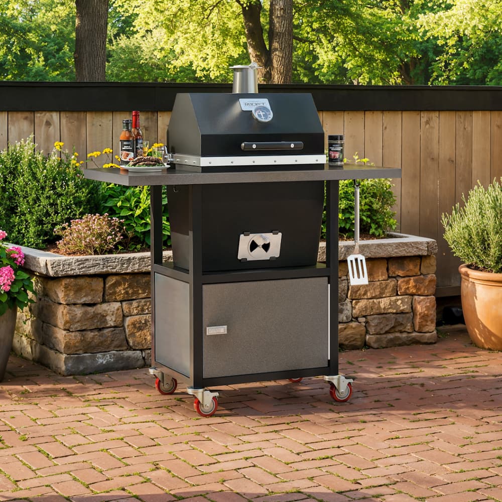 Sonic Rocket grill cart on a brick patio with side shelves, lower storage cabinet, and garden landscaping in the background.